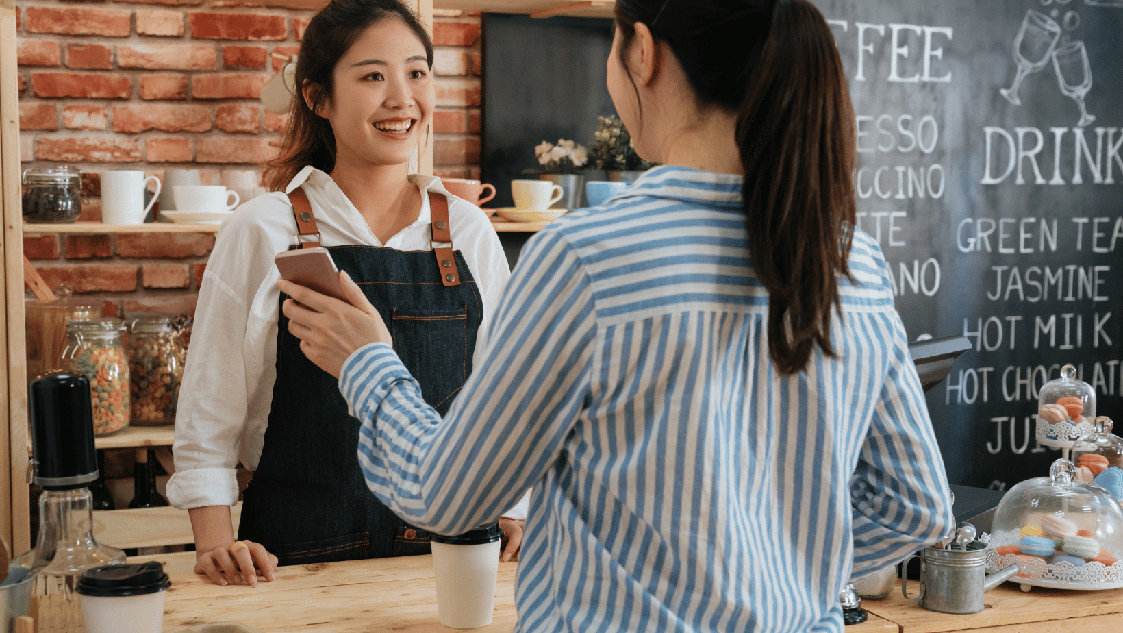 Coffee shop customer paying with her coffee subscription